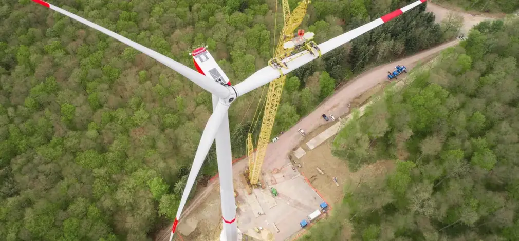 Baustelle für ein Windrad im Wald, Kran hebt Turmsegmente. Baustelle für ein Windrad im Wald, Kran hebt Turmsegmente.