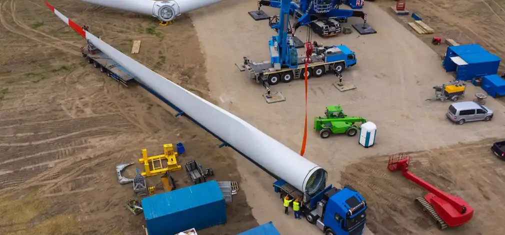 Luftaufnahme einer Windrad-Baustelle im Aufbau mit Baufahrzeugen und Bauteilen. Luftaufnahme einer Windrad-Baustelle im Aufbau mit Baufahrzeugen und Bauteilen.