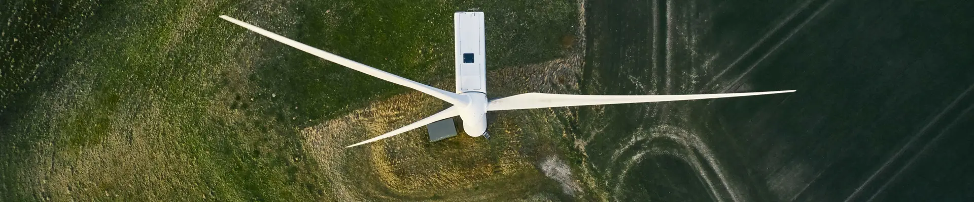 Wind turbine seen from above surrounded by green areas. Wind turbine seen from above surrounded by green areas.