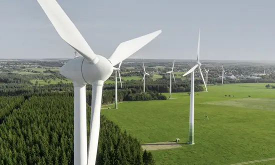 Fünf gute Gründe für ein Windrad auf eigenem Grundstück Luftaufnahme eines Windparks mit vielen Windrädern in weiter Landschaft.