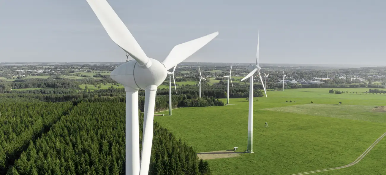 Luftaufnahme eines Windparks mit vielen Windrädern in weiter Landschaft.